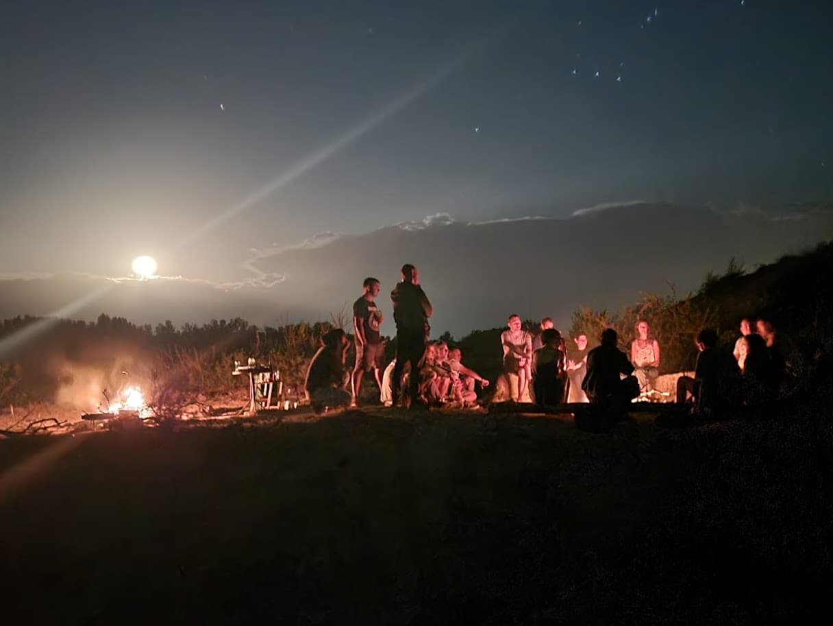 Un fogón de noche, con gente alrededor